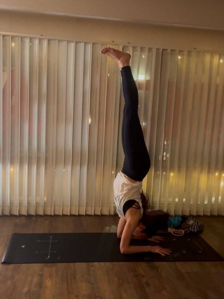 Yoga teacher doing inversion pose Pinchamayulasana